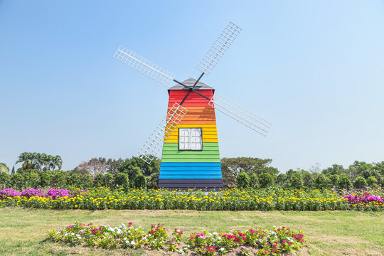 colorful wooden wildmill in public park on blue sky background