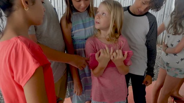 Happy diverse group of young boys and girls looking at a digital tablet together