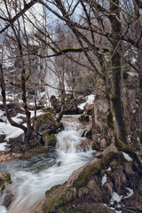 Waterfall Gostilje, Serbia at winter. Snow and ice covered hidden waterfall in the forest in winter.