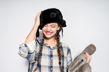girl from Russia in a warm fur hat holds boots