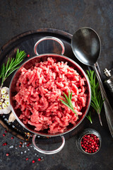 Cooking mince. Raw ground veal meat with ingredients for cooking on black kitchen table. Fresh minced meat, top view