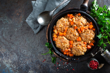 Veal meatballs stewed in frying pan with carrot in vegetable sauce. Delicious meat dish