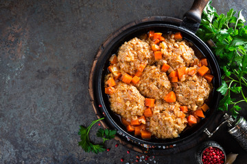 Veal meatballs stewed in frying pan with carrot in vegetable sauce. Delicious meat dish