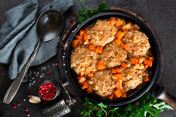 Veal meatballs stewed in frying pan with carrot in vegetable sauce. Delicious meat dish