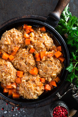 Veal meatballs stewed in frying pan with carrot in vegetable sauce. Delicious meat dish
