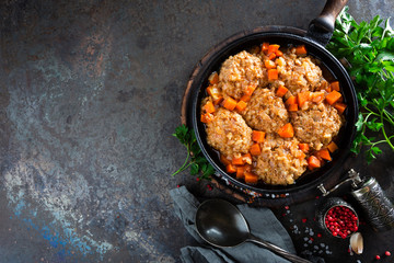 Veal meatballs stewed in frying pan with carrot in vegetable sauce. Delicious meat dish
