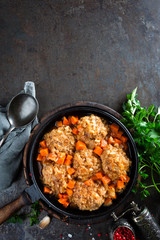 Veal meatballs stewed in frying pan with carrot in vegetable sauce. Delicious meat dish
