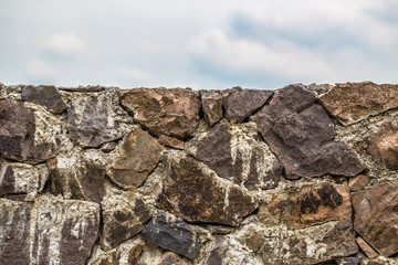 Old stone wall with cloudy sky