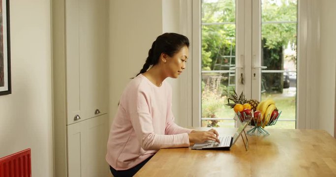 4K Beautiful Asian woman at home using digital tablet with keyboard attached