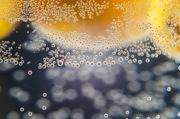 A close-up shot of citrus in a glass of water with lots of bubbles beautiful background for greeting cards and advertising materials.