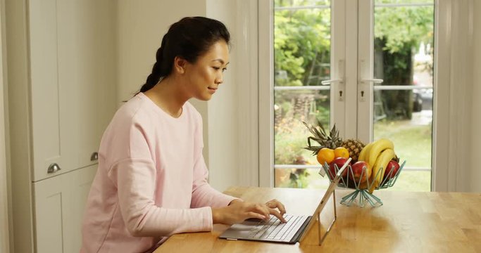 4K Beautiful woman attaching keyboard to digital tablet at home, using the internet for business or leisure
