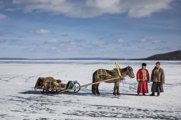 Fototapeta na wymiar mongolian men with their horse sledge on frozen lake Khovsgol