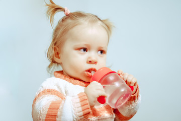 Fototapeta na wymiar little girl drinking from a bottle