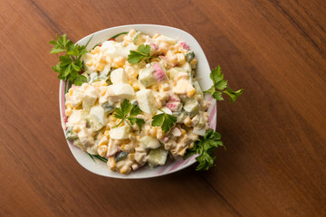 Salad with crab sticks, sweet corn, cucumber, eggs and mayonnaise