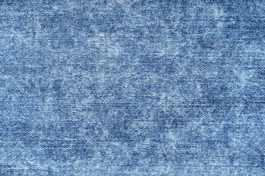 Jeans in acid wash blue. Denim background, texture, close up. Faded wash