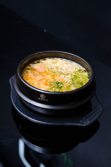 Tasty miso soup with salmon on black rock.