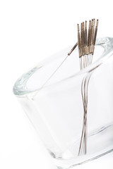 Silver needles for traditional Chinese acupuncture medicine. White background. Selective focus....