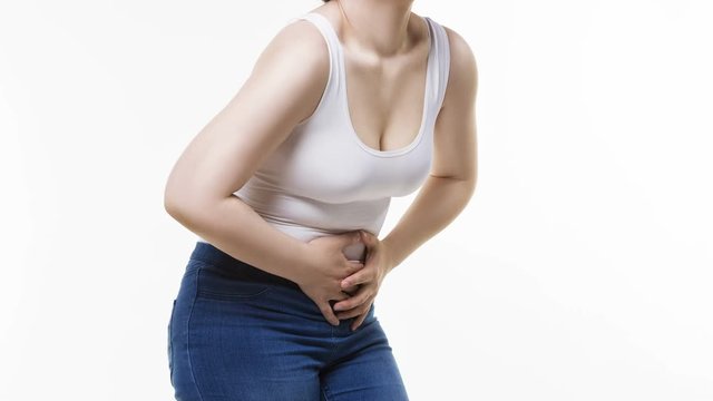 Woman with abdominal pain, stomachache on white background, studio shot