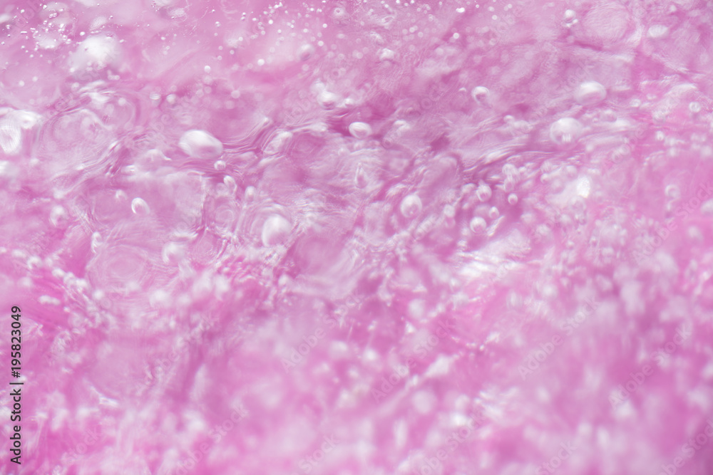 Wall mural close up of air bubbles in ice on pink background