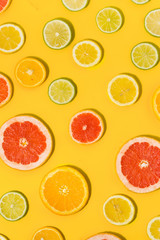 Flat lat top view of sliced citrus fruit on yellow background