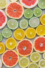 Fototapeta na wymiar Top view of sliced citrus fruit on light background. Flat lay. Summer background