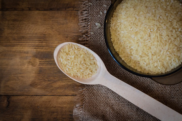 Rice. Steamed rice on wood background and burlap top view