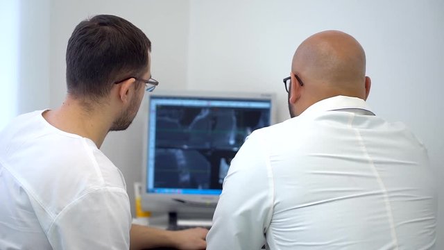 dental assistent discussing with dentist about the tooth's problem on x-ray shot. slow-motion