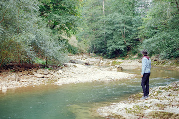 Explorer man standing on the river bank.