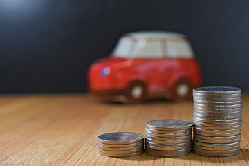 Saving money concept. coin stacks in front of car