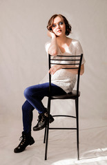 beautiful girl with a short haircut sits in a sunny studio