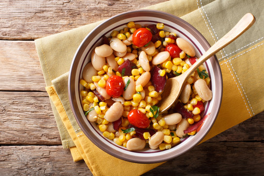 succotash of corn, butter beans, tomatoes and bacon close up in a bowl. horizontal top view