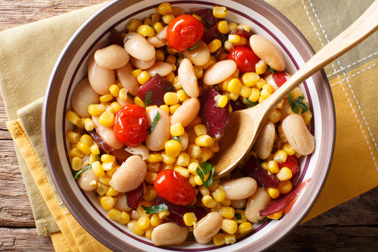 Traditional succotash of corn, butter beans, tomatoes and bacon close up in a bowl. horizontal top view