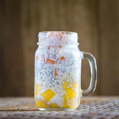 Healthy food, chia seed pudding with mango, green buckwheat, papaya, oat flakes, coconut milk and muesli, vitamin breakfast in glass mug. Morning in Thailand