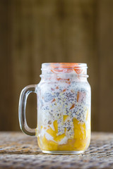 Healthy food, chia seed pudding with mango, green buckwheat, papaya, oat flakes, coconut milk and muesli, vitamin breakfast in glass mug. Morning in Thailand