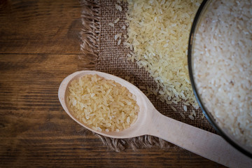 Rice. Steamed rice on wood background and burlap top view