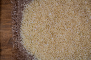 Rice. Steamed rice on wood background and burlap top view