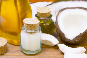 Natural herbal skin care products, top view ingredients coconut, white and yellow bottles with oil on table concept of the best all natural face moisturizer. Facial treatment preparation background