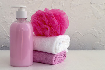 Obraz na płótnie Canvas Liquid soap and two towels on a white background.