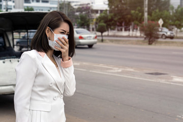 Woman suffer from sick and wearing face mask., asian woman in protective mask feeling bad on the street in the city with air pollution.