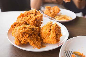 Fried chicken in young woman hand select focus, Hand with fried chicken blur background, Close-up Fried chicken