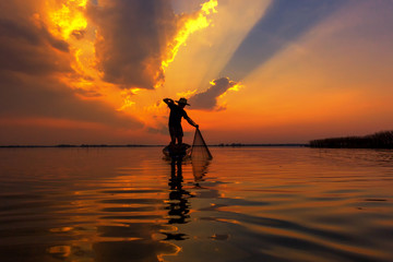 Fototapeta na wymiar Silhouette fisherman with sunset,Take photo fisherman young woman with sunset