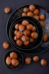 Hazelnuts in metal plate and scattered on table