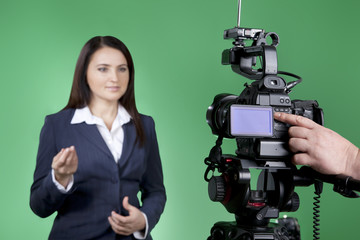 Naklejka premium Video recording news in tv studio. Cameraman working on professional digital equipment. TV host looking at the camera