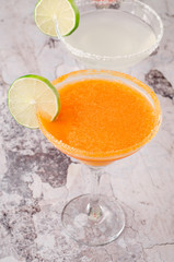 two classic and strawberry margarita, white and red alcoholic cocktail with salt on the edge of the glass, fresh lime, lemon, daiquiri on background restaurant. Bar alcohol menu, sweet drink