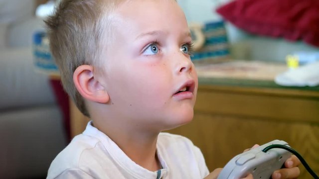 Little boy plays with a video game console