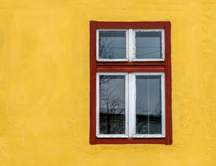 Obraz na płótnie Canvas Old red window frame on a yellow wall