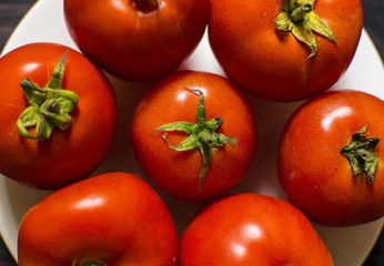 Close-up of fresh, ripe tomatoes on wood background