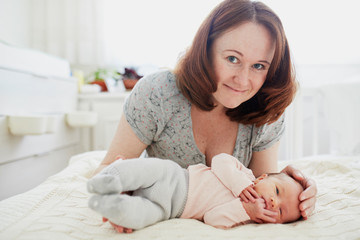 Obraz na płótnie Canvas Beautiful woman with her adorable newborn baby girl