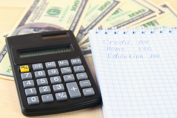 Finance concept : The United States hundred-dollar bills , calculator , bills.