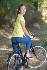 Naklejka premium young woman with bicycle in forest